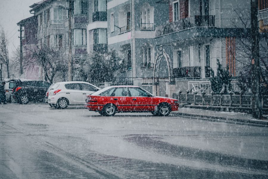 Havas, sós úton parkoló autó télen